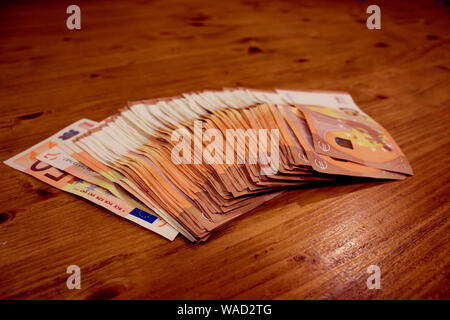 De nombreux billets en papier dans une ligne portant sur une table en bois Banque D'Images