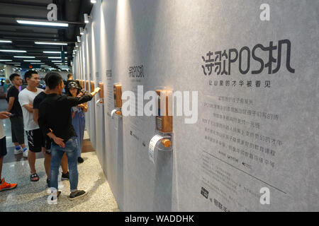 Poème 15 machines POS, par lequel les gens peuvent faire un don 1 yuan chinois à gauche derrière les enfants pour un poème écrit par eux, apparaissent à la station de métro Lujiazui, Banque D'Images