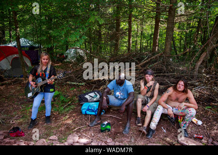 Béthel, United States. Août 18, 2019. Une femme joue de la guitare près du distributeur stand tandis que d'autres participants à l'écoute au cours de la réunion de la route Yasgur Max Yasgur's farm à pendant les célébrations du 50e anniversaire de Woodstock près de Bethel. Organisateur de Woodstock Michael Lang, l'événement a été annulé mais anniversaire les activités ont continué au Arrowhead Ranch, Bethel Woods (le site de l'original Woodstock en 1969), Hector's Inn, et Yasgur's Farm. Credit : SOPA/Alamy Images Limited Live News Banque D'Images