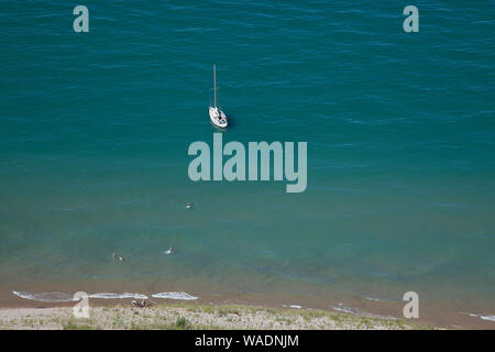 Empire, Michigan, USA. Août 19, 2019. Août 19, 2019, Empire, Michigan, United States ; un voilier flotte à l'ancre sous le Sleeping Bear Dunes National Lakeshore lookout qui est situé dans la partie nord-ouest de la péninsule inférieure du Michigan. La rive est du lac Michigan a créé 400 pieds de hauteur des dunes de sable et des forêts denses, créé après la fonte des glaciers de la dernière époque glaciaire laissant la topographie diversifiée autour de l'Empire, au Michigan. Credit : Ralph Lauer/ZUMA/Alamy Fil Live News Banque D'Images