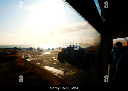 Avis de voyageurs à partir d'une fenêtre de l'autobus sur le pont supérieur du soleil du soir sur la mer Banque D'Images