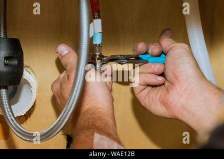 En réparation installation plombier assembler le nouveau robinet mélangeur travailleur mains close up plombier outils et équipements dans une salle de bains Banque D'Images