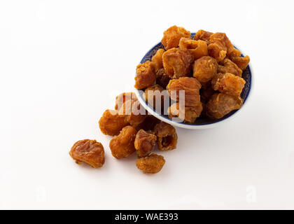 Groupe des longanes séchées dans le plat de fruits et sur fond blanc Banque D'Images