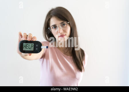 Fille avec glucosometer montre le diabète juvénile que demander de l'aide parce que la glycémie est élevée Banque D'Images