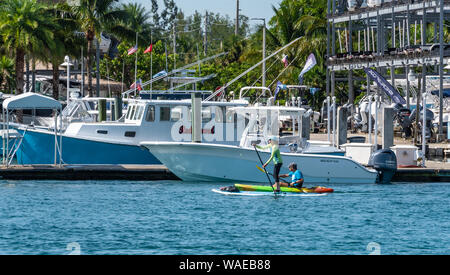 Couple paddle-board et le kayak sur la rivière Wellington à l'entrée de Jupiter, Jupiter dans le comté de Palm Beach en Floride. (USA) Banque D'Images