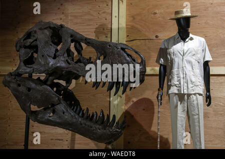 John Hammond's costume porté par Richard Attenborough en 1993 dans le film Jurassic Park (estimation ? ?15-20,000) (au centre) aux côtés d'un monté 5 pieds crâne de Tyrannosaurus rex du film 2018 : Monde Jurrasic royaume déchu (estimation ? ?20 -30 000), au cours d'un essai de la prochaine vente aux enchères des souvenirs de cinéma et de télévision à la prop Store siège social près de Rickmansworth. Banque D'Images