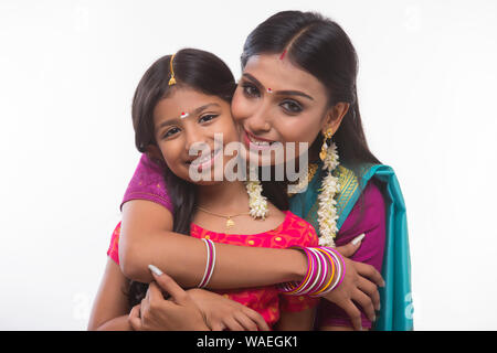 South Indian woman hugging her daughter and smiling at the camera Banque D'Images