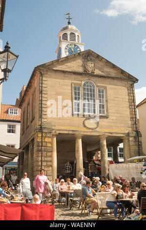 Les gens de manger à la terrasse d'un café à Whitby market place, North Yorkshire, England, UK Banque D'Images