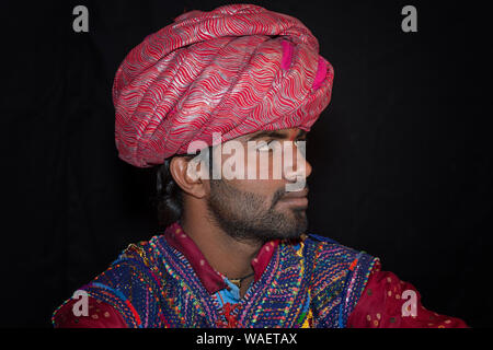 Membre de l'homme Dhebariya Rabari communauté en tissu coloré traditionnel portant un turban rouge, grand désert du Rann de Kutch, Gujarat, Inde Banque D'Images