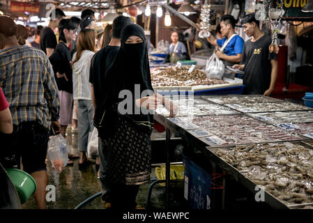 Femme arabe portant un niqab traditionnel couvrant la tête et le visage, shopping dans un marché alimentaire de la Thaïlande Banque D'Images