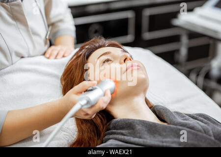 Cosmetologist femelle oxygène rendant la mésothérapie à une femme au salon de beauté de luxe. Concept d'un traitement facial professionnel Banque D'Images
