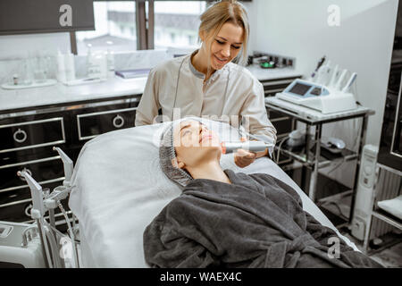 Cosmetologist femelle oxygène rendant la mésothérapie à une femme au salon de beauté de luxe. Concept d'un traitement facial professionnel Banque D'Images