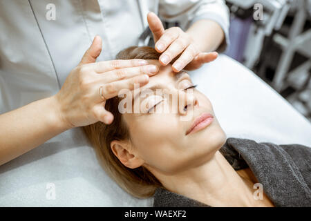 Woman making massage du visage au salon de beauté. Concept d'un traitement de drainage lymphatique Banque D'Images