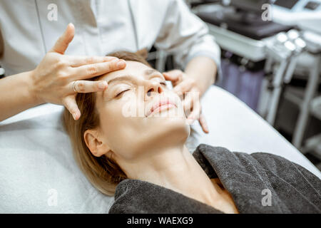 Woman making massage du visage au salon de beauté. Concept d'un traitement de drainage lymphatique Banque D'Images