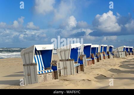 Blanc-bleu chaises de plage à la plage de Westerland avec ciel nuageux, Sylt, le frison du Nord, mer du Nord, l'île de Frise du Nord, Schleswig-Holstein, Allemagne Banque D'Images