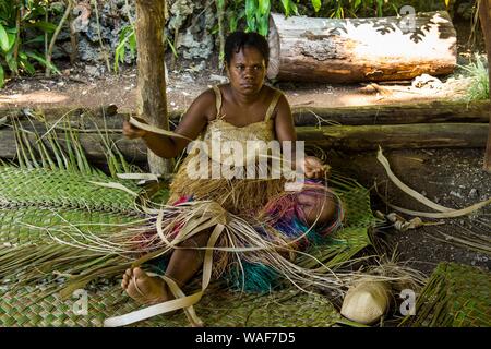 Femme tissant des paniers traditionnels, Ekasup village culturel, Efate, Vanuatu Banque D'Images