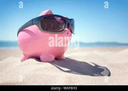 Tirelire avec des lunettes de soleil sur la plage au bord de la mer en été Banque D'Images