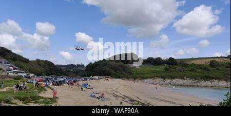 Maenporth, Cornwall, UK. 20 août, 2019. La plage de Maenporth, Cornwall ont été apurées au large de la plage pour permettre à une ambulance d'air à la terre pour aller chercher un blessé. L'air ambulance a atterri et a décollé, pour atterrir dans un champ voisin. La victime a été prise pour le domaine de l'endroit où l'hélicoptère a lui/elle à l'hôpital.L'incident a commencé juste avant midi.Les photos ont été prises à partir de la voie publique. Credit : newspix/Alamy Live News Banque D'Images