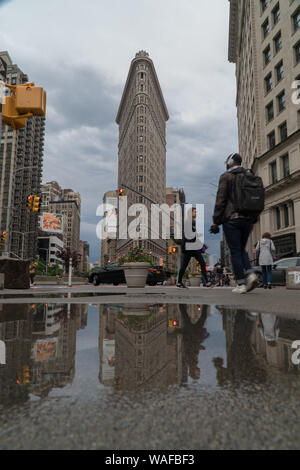 New York City, vers 2019 : Flat Iron building large établissement extérieur shot Street view pendant l'heure de pointe du matin commute. Les gens marchent le long du côté wal Banque D'Images