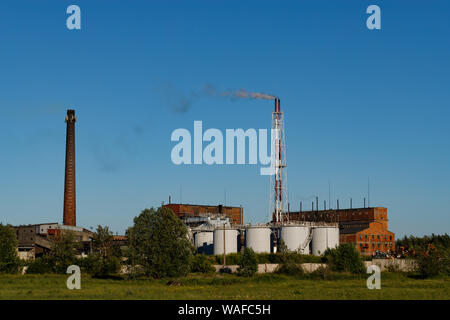 Pile de fumée s'échapper la fumée d'une usine de charbon à partir de la cheminée de fumée contre un ciel bleu clair. Banque D'Images