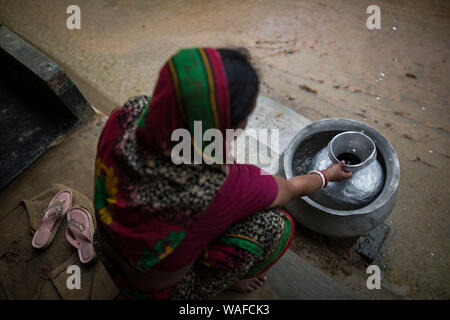 DHAKA, BANGLADESH - 20 août : une femme recueillir l'eau de pluie pour des usages quotidiens dans une zone rurale du Bangladesh le 20 août 2019. Banque D'Images