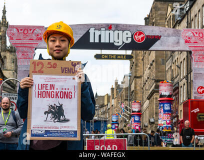 Édimbourg, Écosse, Royaume-Uni, 20 août 2019. Edinburgh Festival Fringe : interprètes sur le Royal Mile d'essayer d'attirer des personnes à leurs spectacles. Artistes d'une exposition intitulée La vie à Hong Kong, d'un mime sur la vie quotidienne et des scènes à Hong Kong Banque D'Images