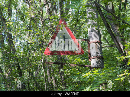Zone d'exclusion de Tchernobyl - Pripyat - Pre 1986 "Méfiez-vous des enfants de l'école' signe maintenant dans les arbres. Banque D'Images