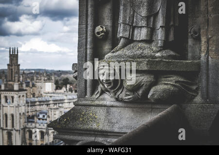 Un gros plan d'une figure de pierre sculptée et de décoration sur la tour de l'église de l'Université St Mary the Virgin, Oxford, Angleterre, Royaume-Uni. Banque D'Images