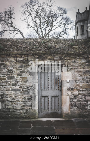 Une porte dans un mur de pierre sur la rue Merton, Oxford, Angleterre. Banque D'Images