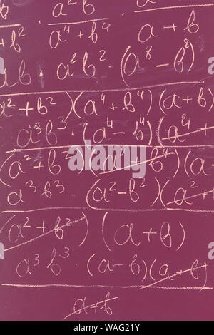 Des formules mathématiques écrit par craie blanche sur le tableau arrière-plan Banque D'Images