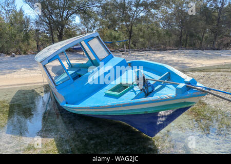 Un bateau stationné à côté de la rive sur Gili Meno, Lombok, Indonésie. Petit bateau de pêche mis en garde et amarrés sur la plage à marée basse. À l'ancre et bateau Banque D'Images