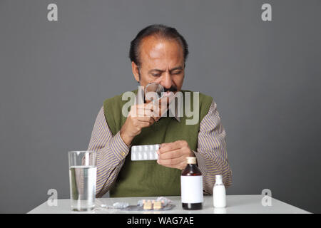 Vieil homme examinant sa médecine Banque D'Images