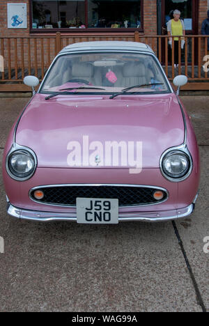 De style rétro Rose 1991 Nissan Figaro 2 profil fixe de porte avant de toit blanc Convertible vue portrait ville japonaise voiture Sandpoint Marina 2 pers Banque D'Images