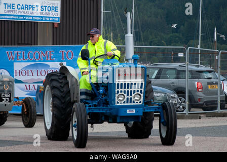 Homme costume jaune bleu 1969 Conduite du tracteur Ford 3000 hors-jeu avant côté conducteur voir des hommes bleu gris brillant véhicule ailes imperméables Sainte fluorescent Banque D'Images