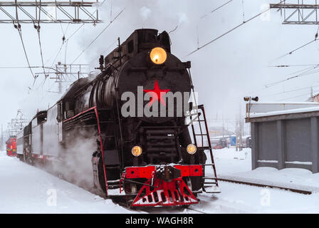 Locomotive à vapeur arrive à la jonction ferroviaire en hiver Banque D'Images