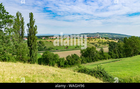 Vallonné et pittoresque paysage de prairies, de pâturages, champs, arbres, ville de Brens et les nuages blancs dans le ciel bleu. Banque D'Images