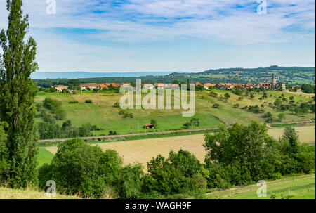 Vallonné et pittoresque paysage de prairies, de pâturages, champs, arbres, ville de Brens et les nuages blancs dans le ciel bleu. Banque D'Images