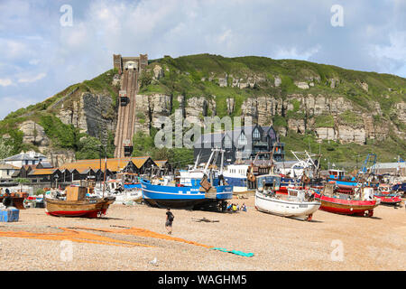 Les bateaux de pêche avec paraphenalia sur la plage de galets de la vieille ville, avec le funiculaire escarpé int il fond, Hastings, East Sussex, UK Banque D'Images