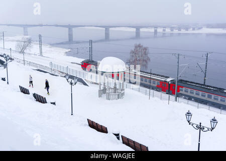 Paysage de neige d'hiver avec train électrique le long de la rivière avec une rotonde et pont vintage automobile dans l'arrière-plan, f Banque D'Images