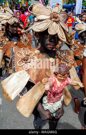 Les enfants vêtus de costumes tribaux parade dans les rues de Santo Nino Statues pendant le Festival Ati-Atihan, Kalibo, Philippines Banque D'Images