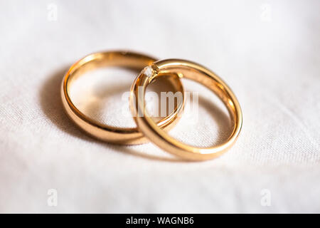 Macro photo de deux anneaux de mariage posé sur un tissu blanc Banque D'Images