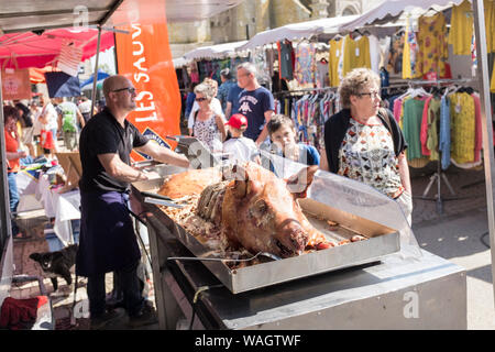 L'ensemble d'un cochon rôti à la vente à l'hebdomadaire le marché en plein air à Plougasnou, France Banque D'Images