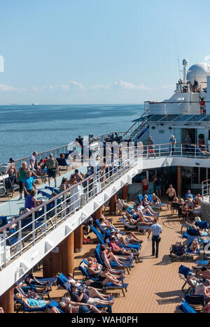 Les passagers à prendre le soleil sur la terrasse de la piscine d'un navire de croisière Banque D'Images