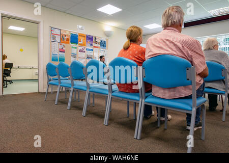 Vue arrière de gens assis dans une salle d'attente des médecins Banque D'Images