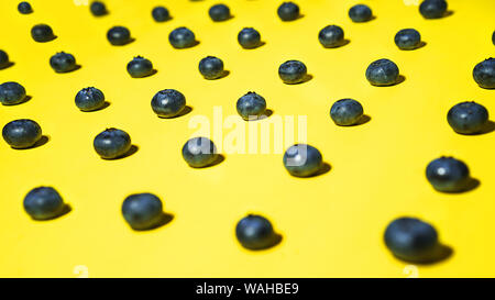 Modèle de bleuets frais sur fond jaune. Banque D'Images