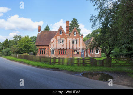 Vue sur Orchard Cottage, une architecture gothique victorien vide en construction , Surrey village Wisley, le sud-est de l'Angleterre avec le quadrillage à la maçonnerie Banque D'Images