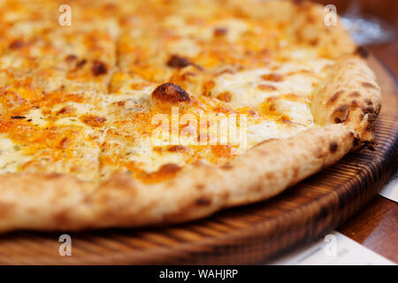 Quatre fromages pizza cuite au four à bois four frit, close-up sur le service à bord Banque D'Images