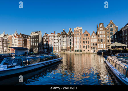 Bateaux de croisière amarrés sur le canal d'Amsterdam Damrak Banque D'Images