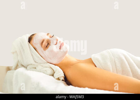 Une femme en cosmetologic masque sur un fond gris. Banque D'Images