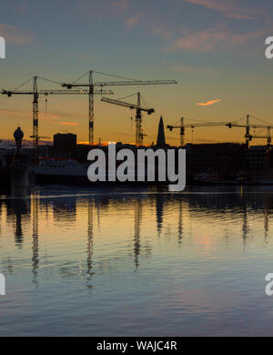 L'Islande, Reykjavik, le vieux port. Clocher de l'église Hallgrimskirkja et silhouettes de grues au lever du soleil. En tant que crédit : Wendy Kaveney Jaynes / Galerie / DanitaDelimont.com Banque D'Images